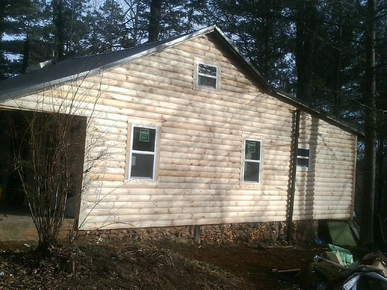 New log siding and dark metal roofing on a gable end in Wheatland